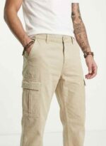 Redefine your everyday carry and comfort with the BREXX Urban Utility Beige Cargo Pants. Designed for the man who values both function and fashion, these trousers are the ultimate addition to a versatile wardrobe. Whether you are navigating the urban jungle or heading out for a casual weekend, the structured design ensures you look sharp without compromising on comfort. Key Features & Benefits: Premium Cotton Twill: Crafted from high-grade, breathable cotton fabric that offers superior durability and a soft hand-feel. Multi-Functional Storage: Equipped with deep side cargo pockets with secure flap closures, perfect for phones, wallets, and keys, plus standard front and back pockets. Modern Tapered Fit: expertly tailored to provide a relaxed feel at the thighs while tapering neatly at the ankles for a clean, contemporary silhouette. Reinforced Construction: Features heavy-duty stitching on belt loops and stress points to ensure longevity. Versatile Styling: The neutral beige tone pairs effortlessly with t-shirts, hoodies, or button-downs for year-round wear. Upgrade your rotation with the pants that work as hard as you do. Experience the perfect blend of tactical utility and street-ready style with BREXX